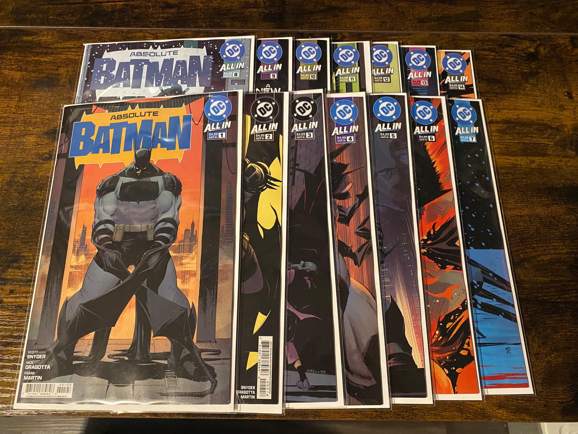 Collection of comic books featuring Batman on a wooden surface